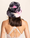Person wearing a fluffy, multicolored hat on a beige background