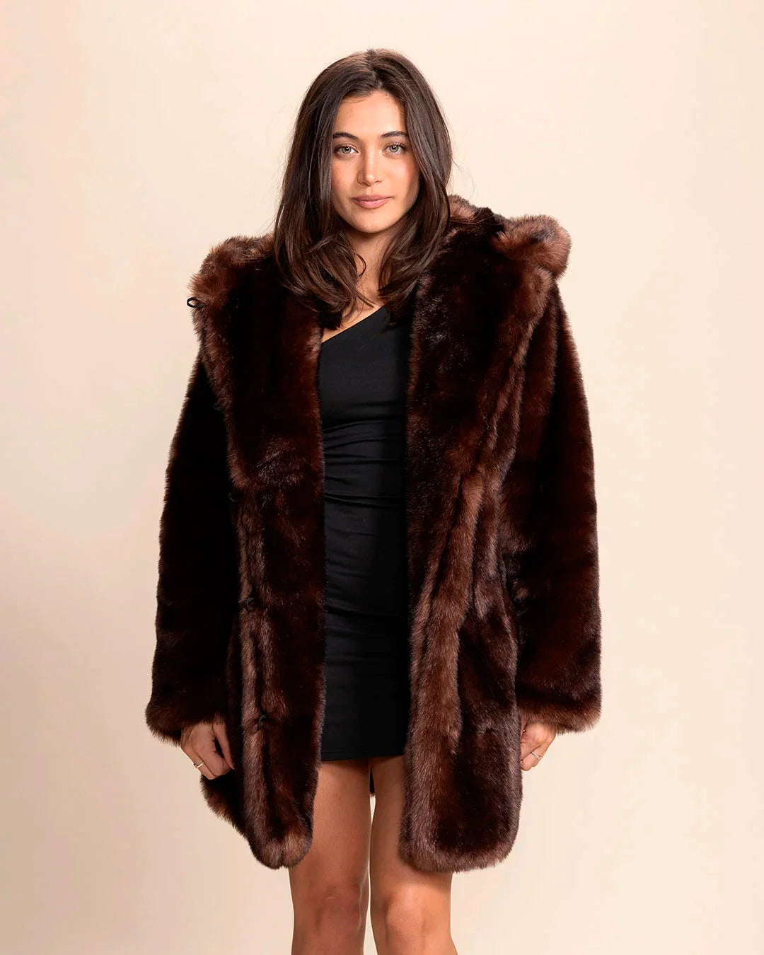 Model with shoulder length brown hair smiling at the camera wearing SpiritHoods luxe collector edition deep chocolate brown faux fur coat with the hood down.