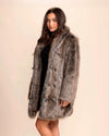 Woman wearing a SpiritHoods collared faux fur coat in Dire Wolf, featuring soft greys, browns, and blacks, with wolf buttons, against a plain background
