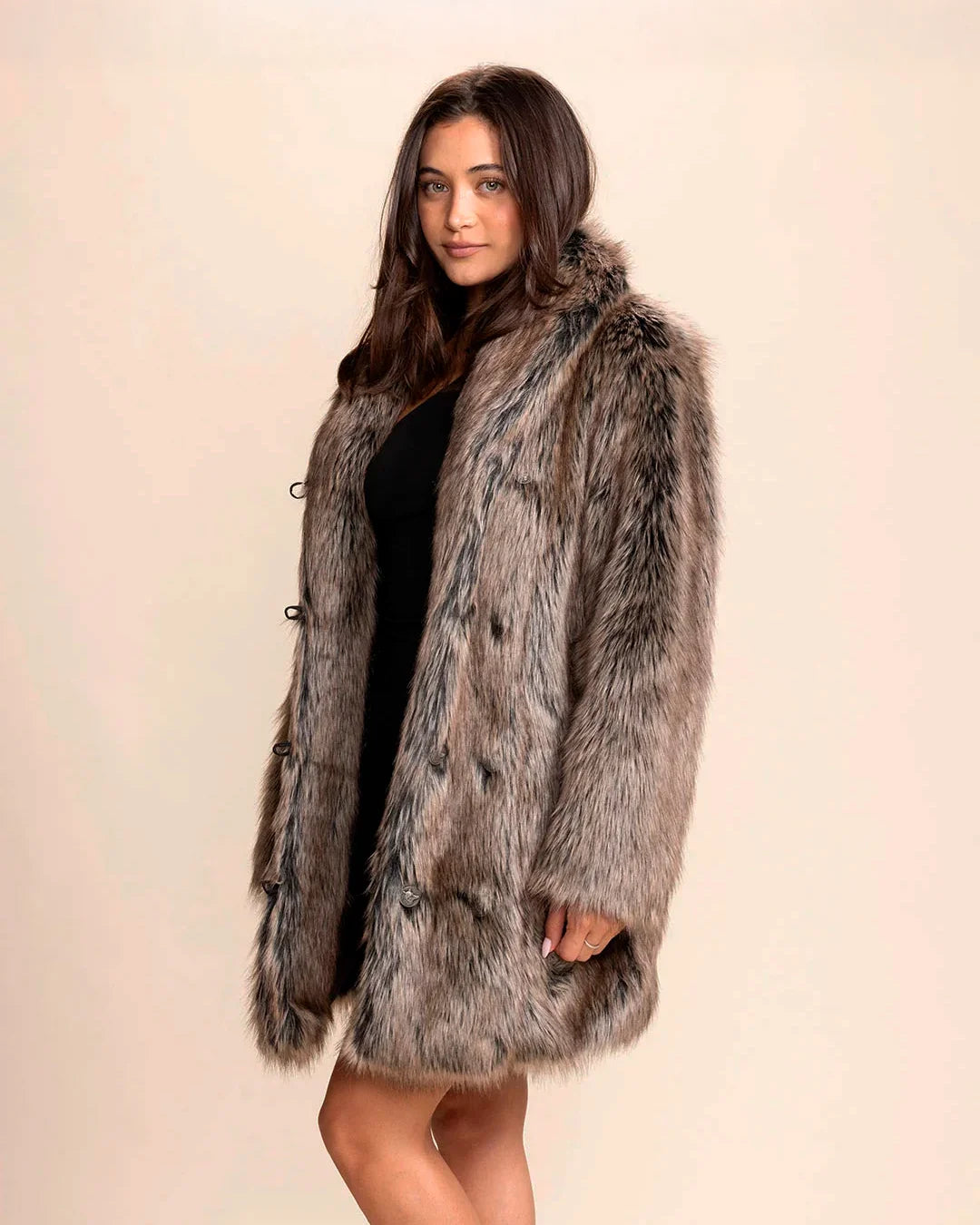 Woman wearing a SpiritHoods collared faux fur coat in Dire Wolf, featuring soft greys, browns, and blacks, with wolf buttons, against a plain background