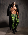 Man wearing neon green leopard print velvet leggings and a black panther fake fur floor length coat against a gray background