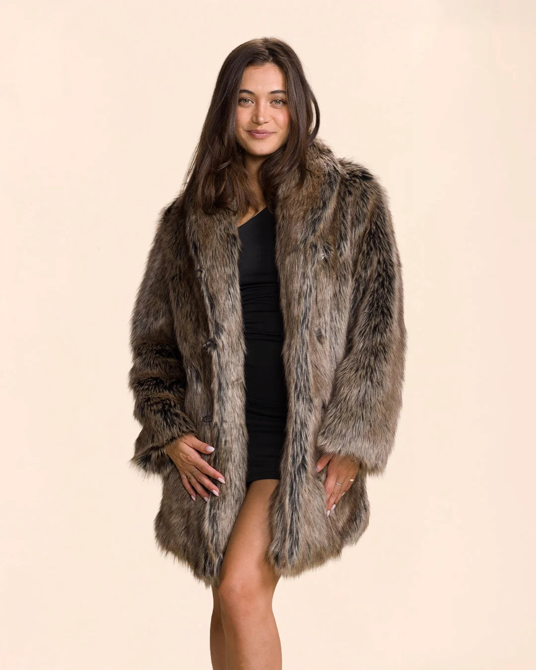 Woman wearing a grey animal print fake fur jacket by SpiritHoods on a beige background. Luxury vegan jacket styles with a black mini dress.
