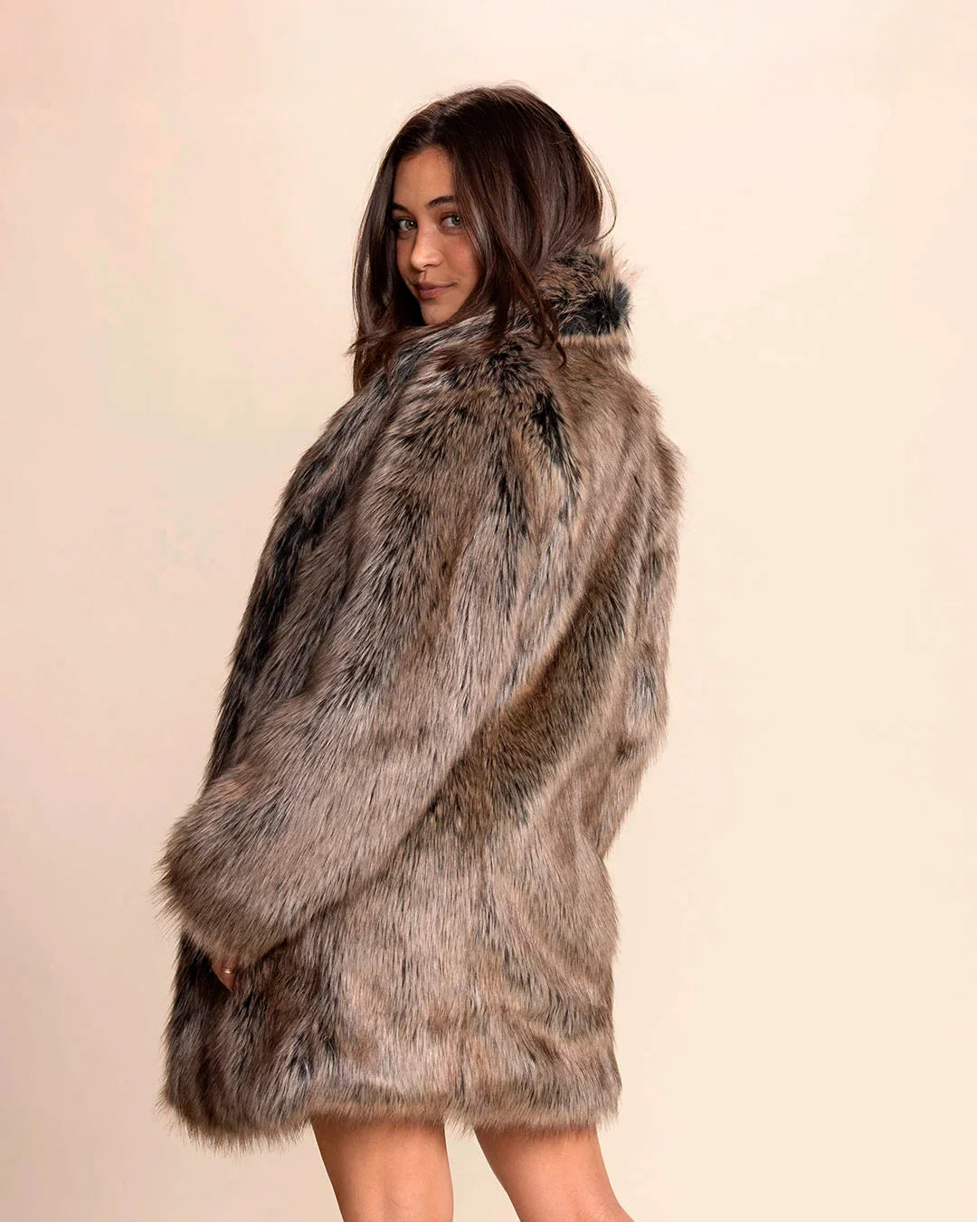 Woman wearing a Top-Rated Collared Fake Fur Coat in SpiritHoods best-selling Dire Wolf faux fur against a plain background