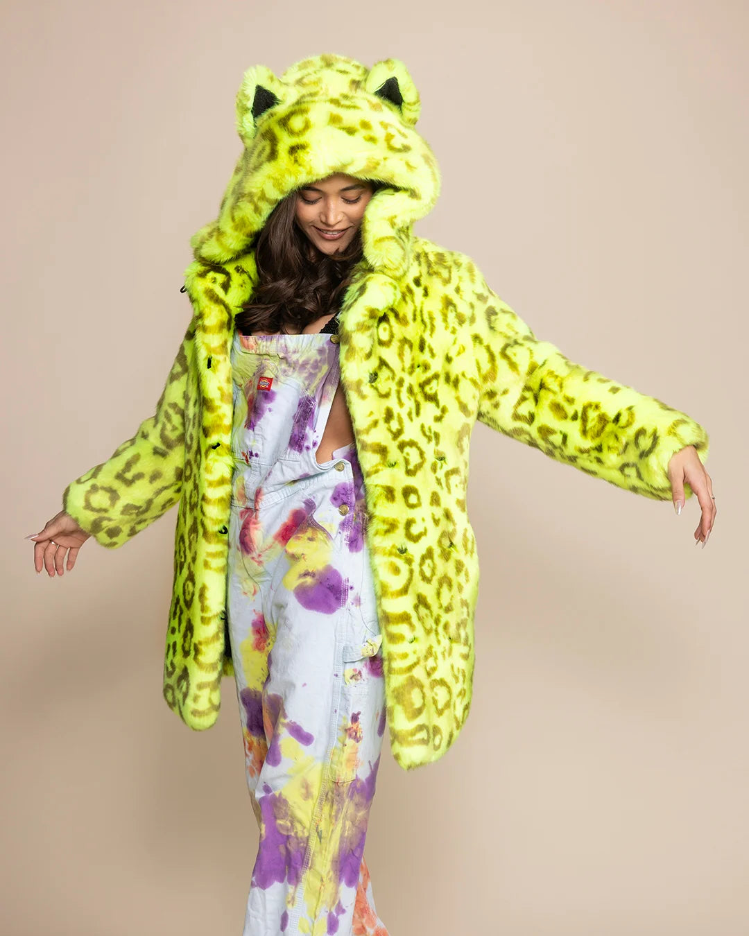 Woman wearing a Neon Yellow Leopard Luxury Faux Fur coat with an oversized hood and ears that glows under UV blacklight