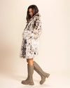 Woman wearing a patterned animal print faux fur jacket and knee-high boots on a beige background. SpiritHoods Custom Made Fall Coats and Fake Fur Jackets for Women