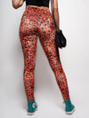 Woman Wearing Black Top Modeling Back View of Sunrise Cheetah Velvet Leggings