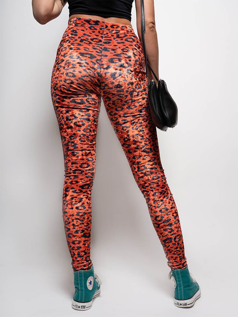 Woman Wearing Sunrise Cheetah Velvet Leggings and Turquoise High-Top Sneakers