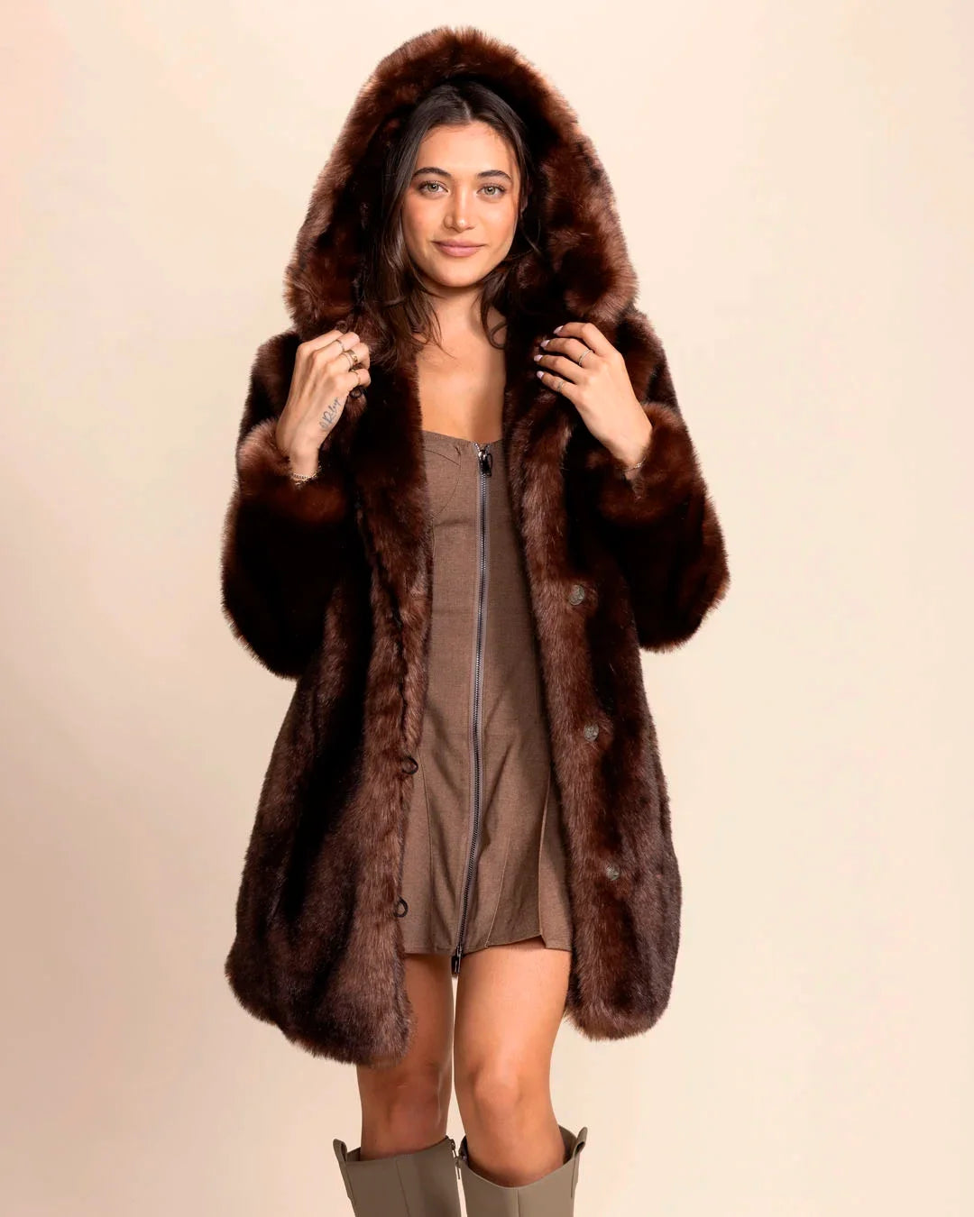 SpiritHoods Women's Faux Fur Coat in brown wolf fake fur. Hooded luxury vegan fake fur jacket styled with a brown mini-dress and fall boots.