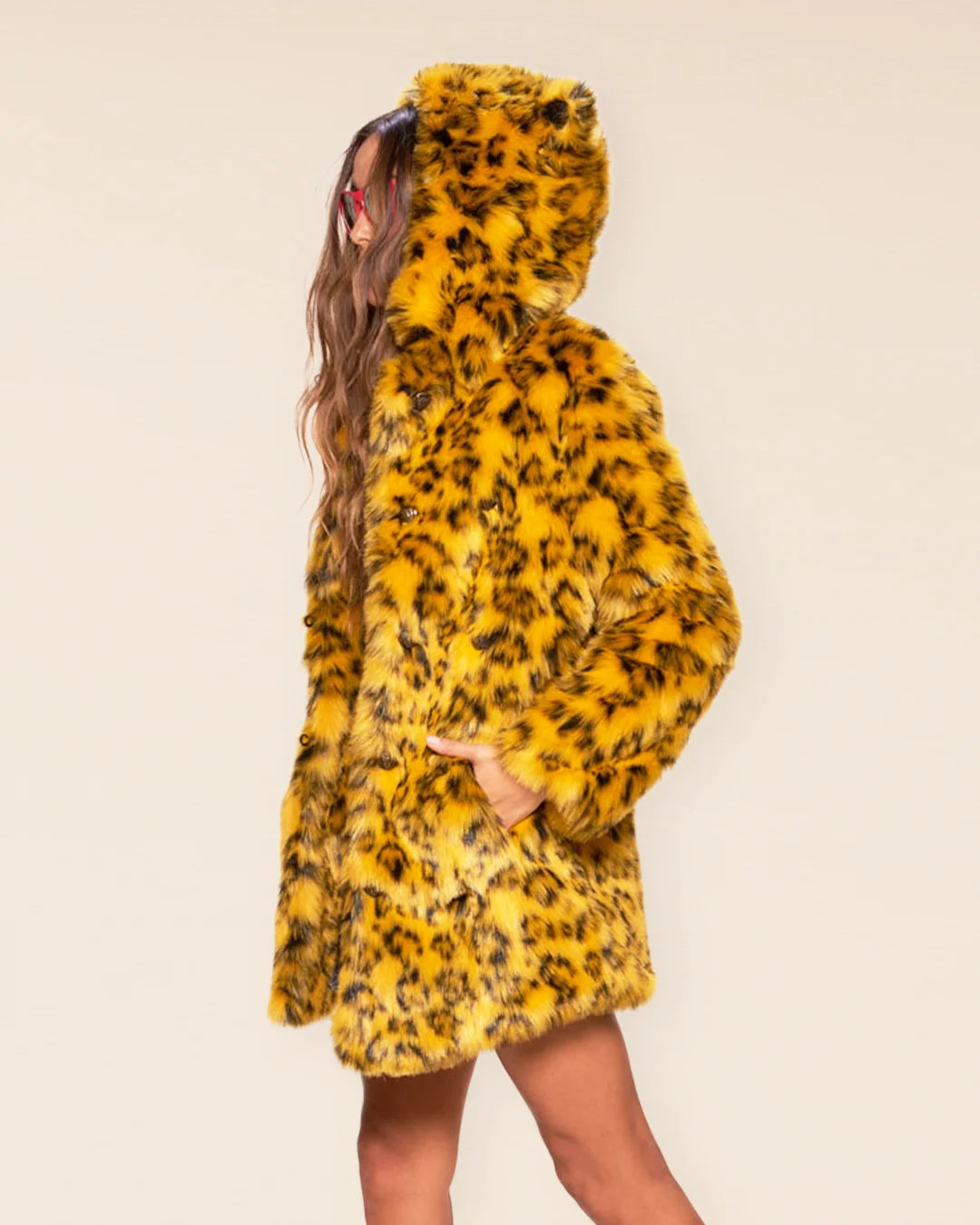 Woman wearing a Yellow Cheetah Classic faux fur coat with an oversized hood and animal ears.