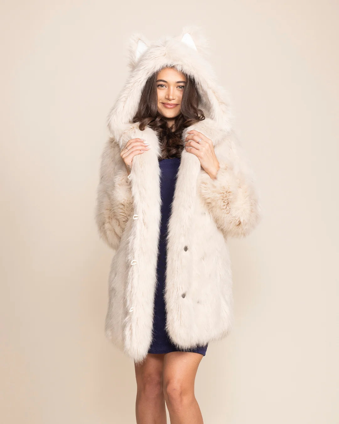 Woman wearing an Arctic Wolf Classic white faux fur coat with an oversized hood and wolf ears.