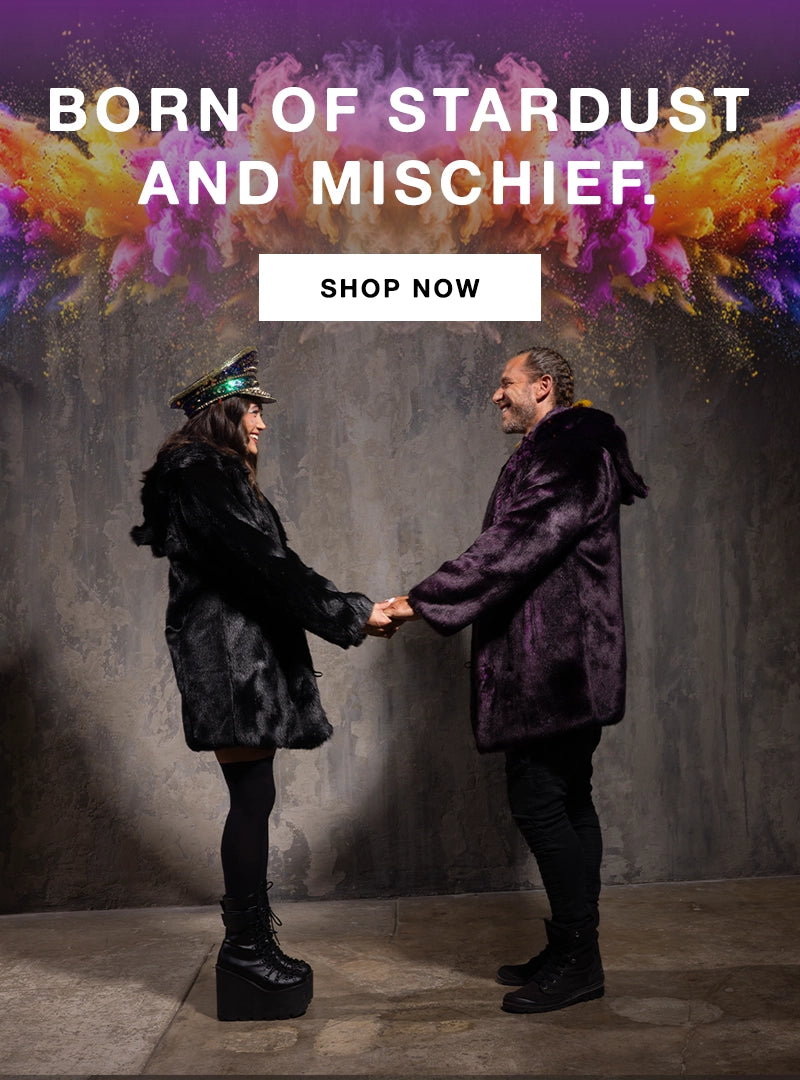 Two people holding hands with a colorful explosion and promotional text 'Born of Stardust and Mischief. Shop Now'