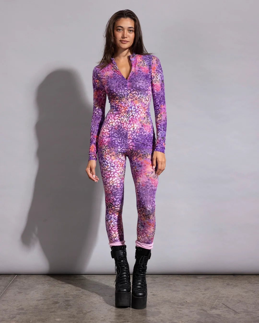 Lightweight tie-dye leopard print rave bodysuit paired with black combat platform boots for festival fashion.