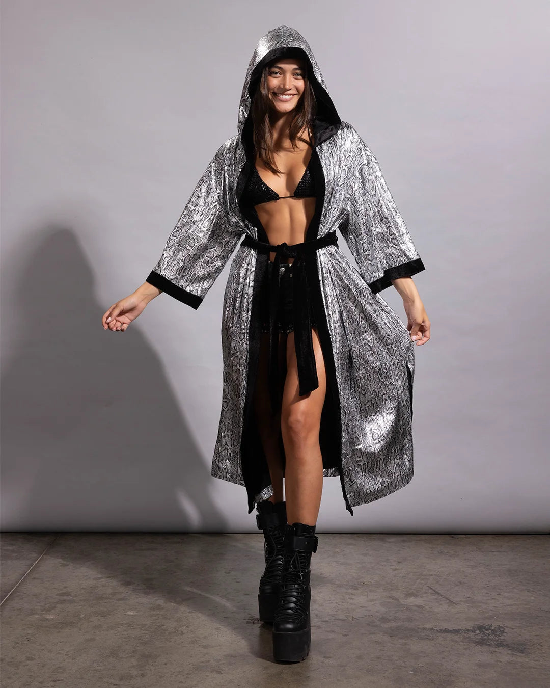 Woman smiling in a silver snakeskin sequin festival kimono featuring a lightweight draped silhouette and cozy hood.