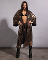 Woman smiling in a gold leopard sequin festival kimono with a deep hood and shimmering metallic pattern.