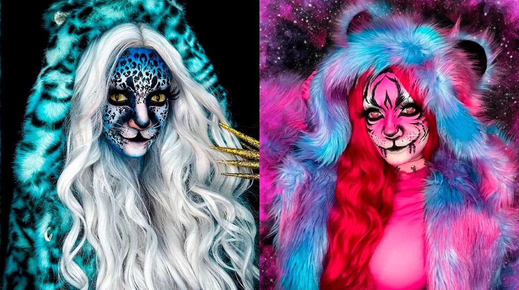 Two individuals with elaborate makeup and costumes, one with white hair and blue accents, the other with pink and blue fur.