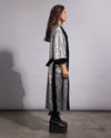 Full-length view of a hooded silver sequin duster coat in a reptile print pattern with a soft, breathable interior.