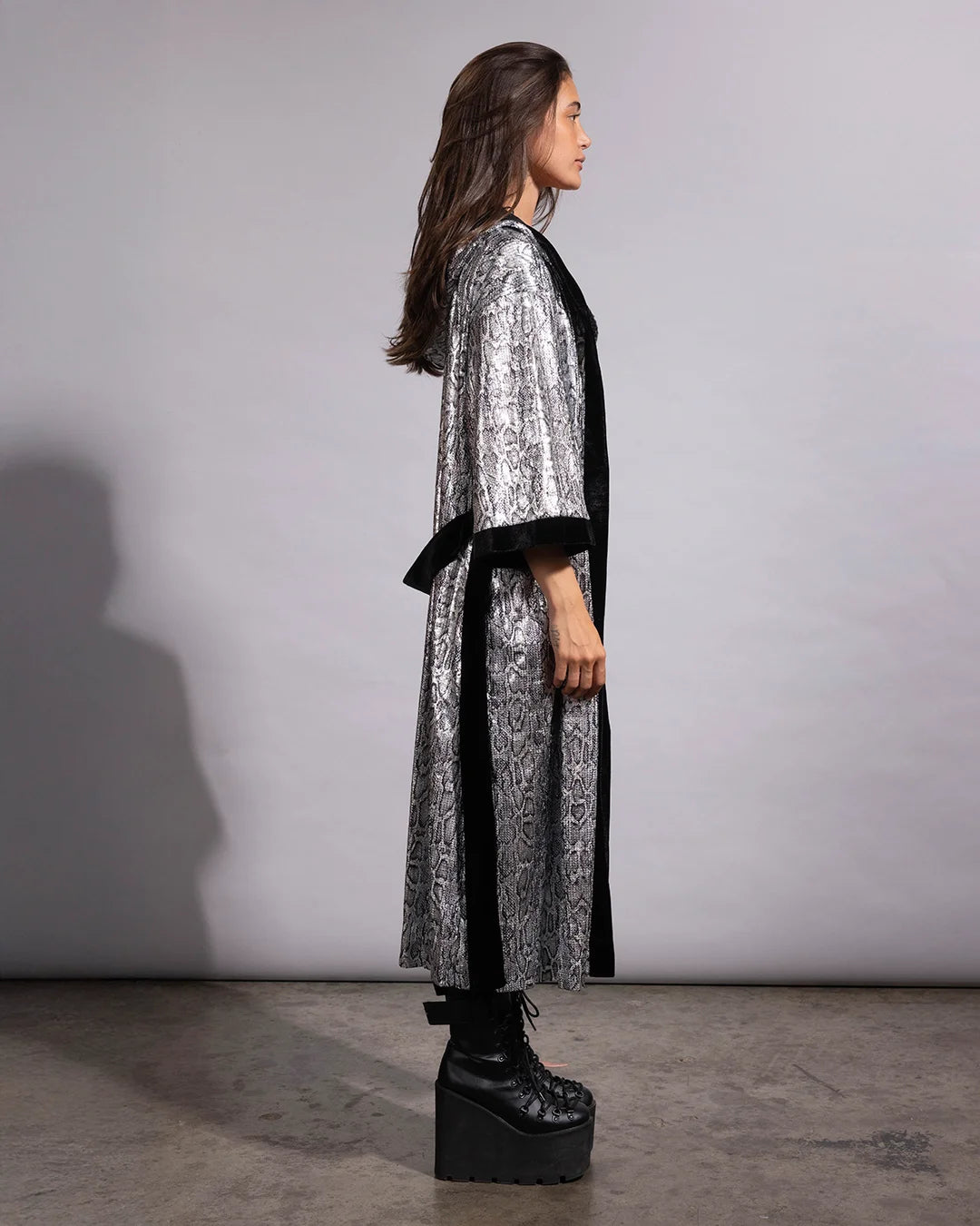 Full-length view of a hooded silver sequin duster coat in a reptile print pattern with a soft, breathable interior.