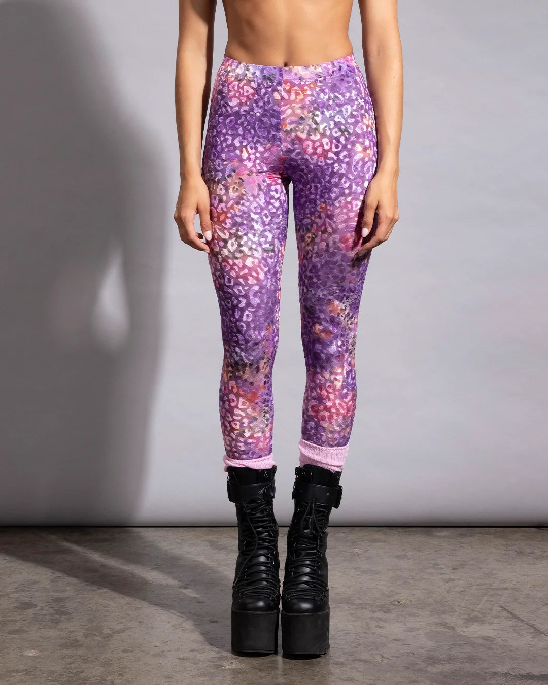 Lightweight tie-dye leopard rave leggings styled with pink socks and black platform combat boots for a festival look.