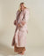Woman wearing Rose Quartz Wolf Luxe Classic Faux Fur Robe, side view 1