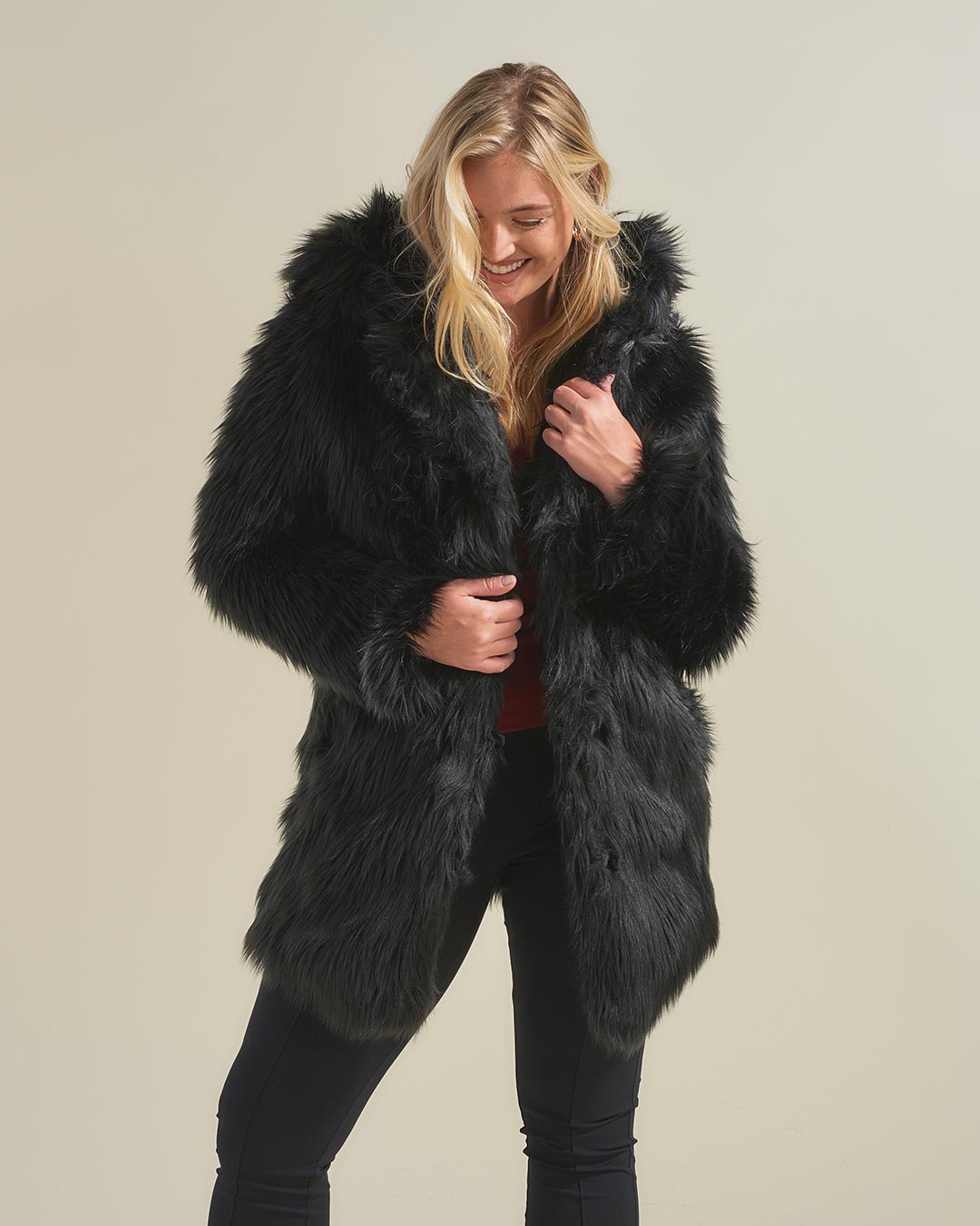 Woman With Blonde Hair Looking Down and Wearing Black Wolf Faux Fur Coat Without Hood