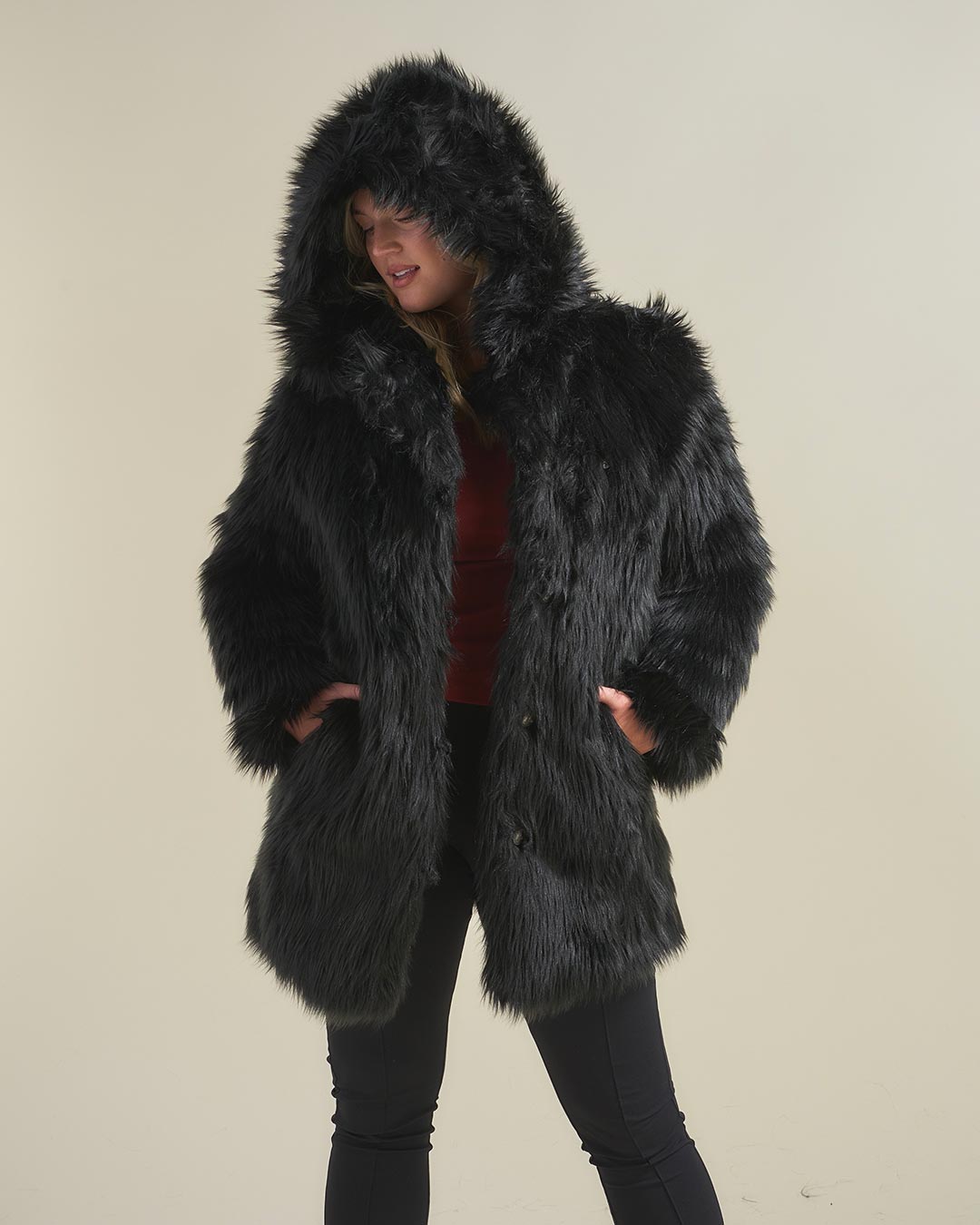 Woman Looking Down With Hands in Pockets While Wearing Black Wolf Hooded Faux Fur Coat