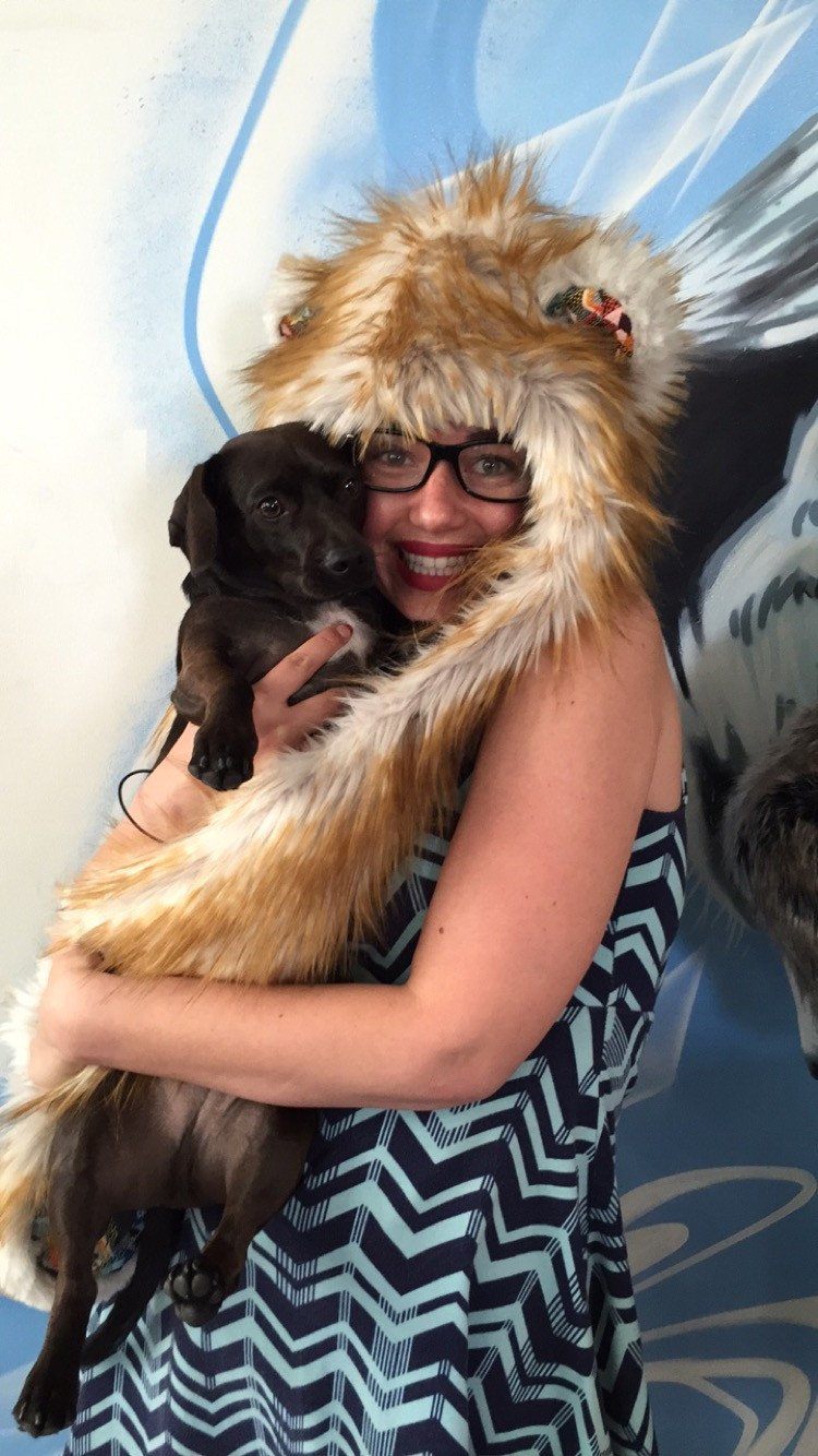 Woman wearing faux fur Adventure Sunset Bear SpiritHood holding puppy
