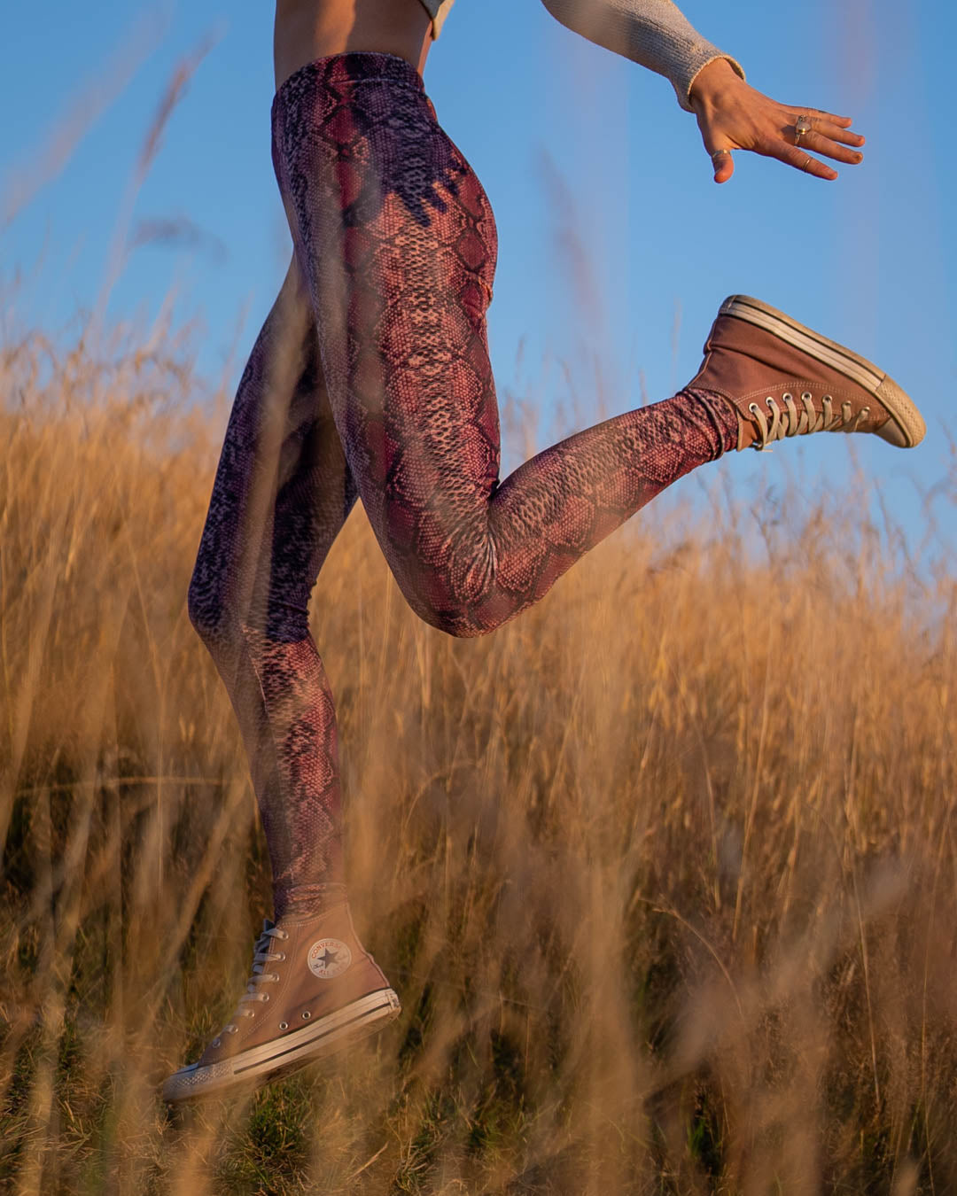 Woman Jumping in Pink Python High-Waisted Velvet Leggings
